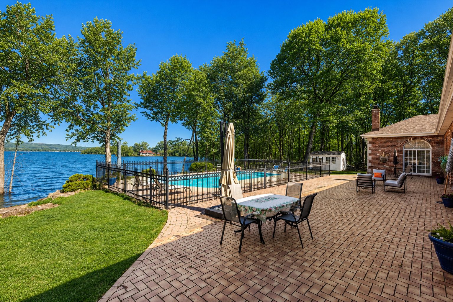Terrasse pavée et piscine face au Lac des Deux Montagnes